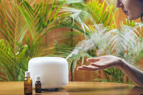 Woman-breathing-in-steam-scent-from-essential-oil-diffuser